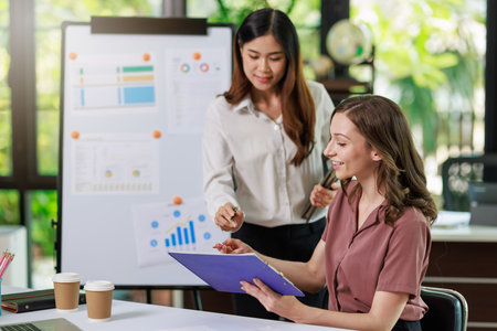 Concept of business office woman working,Businesswoman smile while working about her invesment plan with analyzing document and business investment graph data by using laptop on desk in workstation.の写真素材