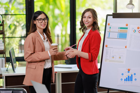 Concept of business office woman working,Businesswoman smile while working about her invesment plan with analyzing document and business investment graph data by using laptop on desk in workstation.の写真素材