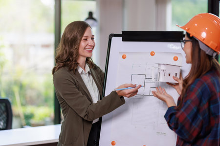 Construction concept of Engineer and Architect working with Construction model and blueprint before buit at site, Engineer and Architect discussing construction plan with computer laptop calculatorの写真素材