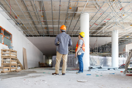 Construction concept of Engineer and Architect working with construction model and blueprint at construction site, Engineer and Architect discussing construction plan at building siteの写真素材