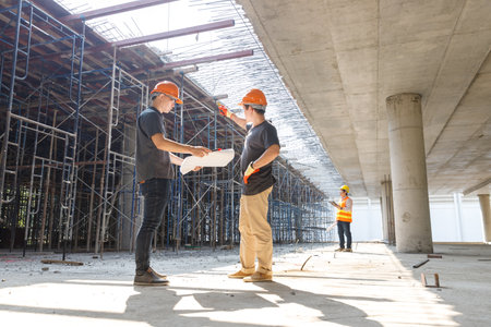 Construction concept of Engineer and Architect working with construction model and blueprint at construction site, Engineer and Architect discussing construction plan at building siteの写真素材