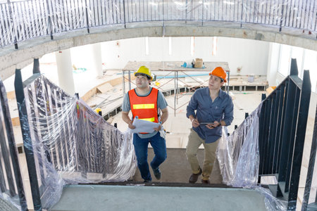 Construction concept of Engineer and Architect working with construction model and blueprint at construction site, Engineer and Architect discussing construction plan at building siteの写真素材