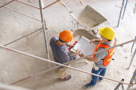 Construction concept of Engineer and Architect working with construction model and blueprint at construction site, Engineer and Architect discussing construction plan at building siteの写真素材