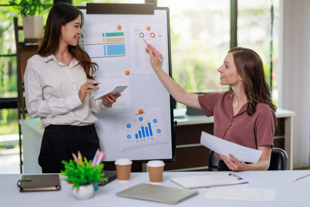 Concept of business office woman working,Businesswoman smile while working about her invesment plan with analyzing document and business investment graph data by using laptop on desk in workstation.の写真素材