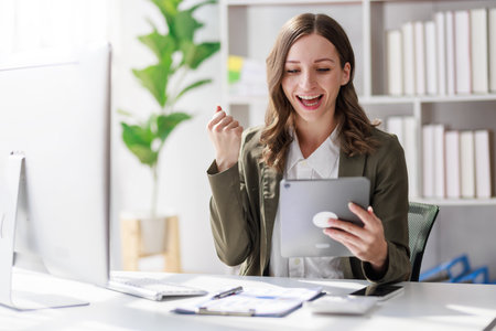 Concept of business investment or working woman,  Businesswoman wearing a suit sitting and working on analysis of business investment documents and using computer to analytic business data.の写真素材