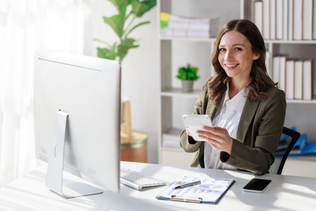 Concept of business investment or working woman,  Businesswoman wearing a suit sitting and working on analysis of business investment documents and using computer to analytic business data.の写真素材