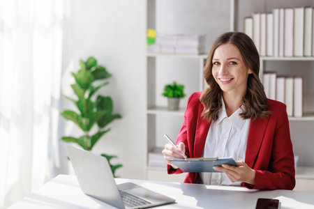 Concept of business investment or working woman,  Businesswoman wearing a suit sitting and working on analysis of business investment documents and using computer to analytic business data.の写真素材
