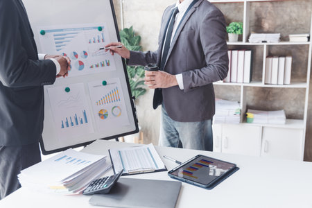 Finance and investment concept, Businessman present business finance investment plan with his partner, Investor colleagues discussing new investment plan by financial graph data on office tableの写真素材