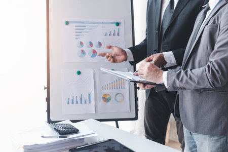 Finance and investment concept, Businessman present business finance investment plan with his partner, Investor colleagues discussing new investment plan by financial graph data on office tableの写真素材