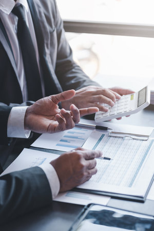 Finance and investment concept, Businessman present business finance investment plan with his partner, Investor colleagues discussing new investment plan by financial graph data on office tableの写真素材