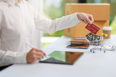 Concept of Online shopping, e-commerce, Woman holding credit card and using laptop computer for shopping online,Businesswoman paying for goods or services using credit card through online channelsの写真素材