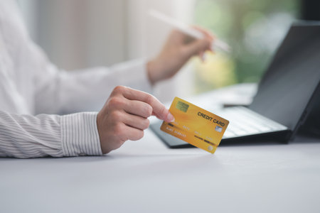 Concept of Online shopping, e-commerce, Woman holding credit card and using laptop computer for shopping online,Businesswoman paying for goods or services using credit card through online channelsの写真素材