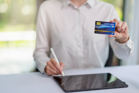 Concept of Online shopping, e-commerce, Woman holding credit card and using laptop computer for shopping online,Businesswoman paying for goods or services using credit card through online channelsの写真素材