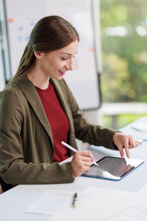 Concept of business office woman working,Businesswoman smile while working about her invesment plan with analyzing document and business investment graph data by using laptop on desk in workstation.の写真素材