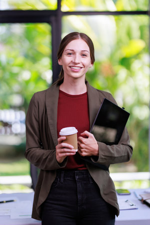 Concept of business office woman working,Closeup businesswoman checking her invesment plan with analyzing document and business investment graph by using calculator and laptop while holding coffee cupの写真素材