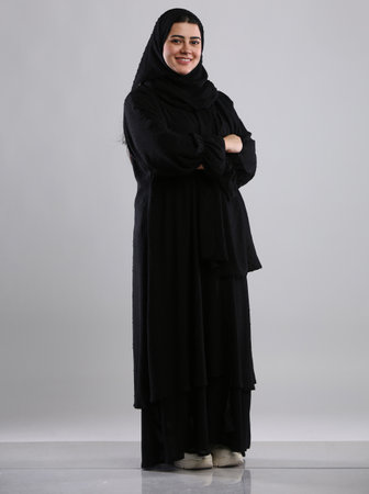 Portrait of a beautiful muslim woman wearing hijab with arms crossedの写真素材