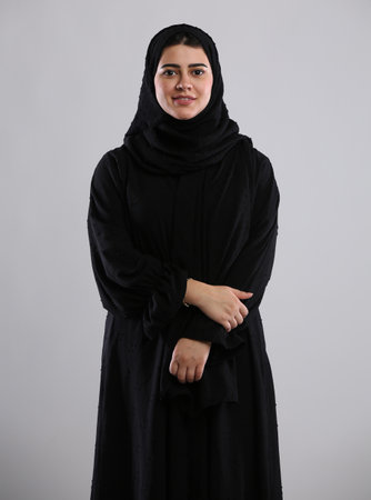 Portrait of a young muslim woman wearing hijab against gray backgroundの写真素材