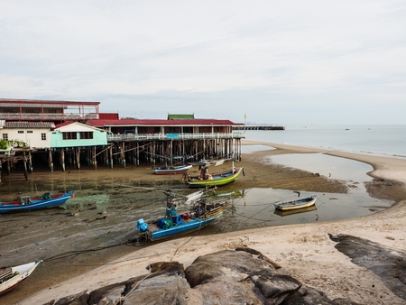 Small fishing boats on mud by the seasideの写真素材