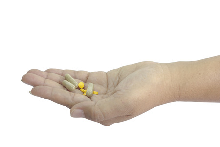 woman's hand holding pills on white backgroundの写真素材