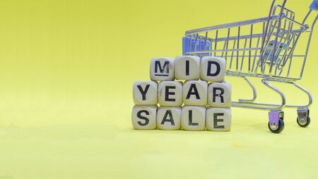 Small shopping cart on yellow floor, ready for sale MID YEAR.の写真素材
