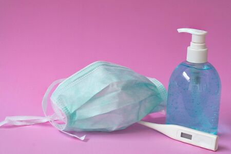 Coronavirus prevention with medical surgical mask, hand sanitizer, alcohol gel and thermometerの写真素材