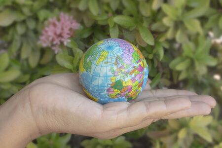 Woman hand holds the earth on blur background. The concept of Earth Day.の写真素材