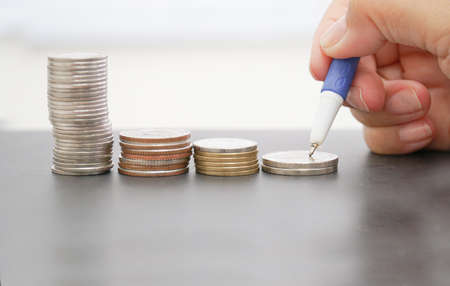 The arrangement of the coin and à¸´businesswoman Writing On Paper At Table.