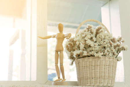 Wooden puppet and flower pot in coffee cafe. Dried flowers in a vase.