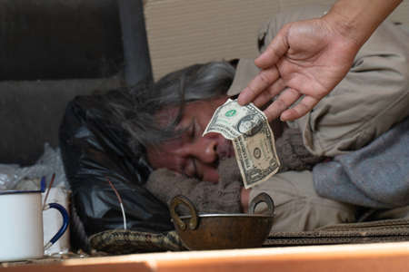 Dollar bill. Man giving one dollar bill to homeless man.の写真素材