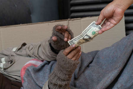 Dollar bill. Man giving one dollar bill to homeless man.の写真素材