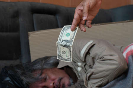 Dollar bill. Man giving one dollar bill to homeless man.