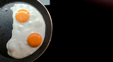Two fried eggs in a teplon pan.の写真素材
