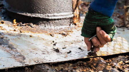 worker using hands screws to repair metal roofの写真素材