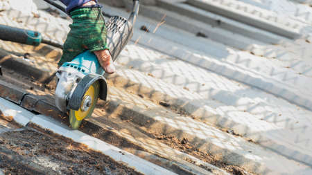 Workers are using grinding stones, cutting, fixing steel roofs.