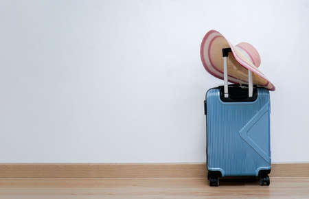 travel bag with wheels, straw hat  on white wall background.の写真素材