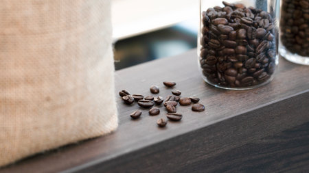 coffee beans in a glass jar on wooden table, stock photoの写真素材