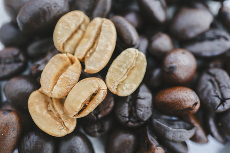 Close up of roasted and unroasted coffee beans showcases their contrasting colors and textures,...