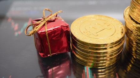 Gold coins and red gift box on black background, stock market conceptの写真素材