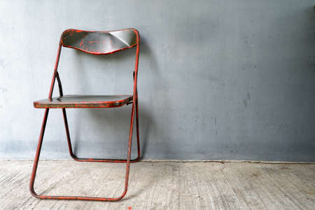 Old steel chair placed with gray background.の写真素材