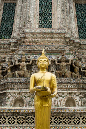 The golden buddha statue in front of the pagoda at the public temple in Thailandの写真素材