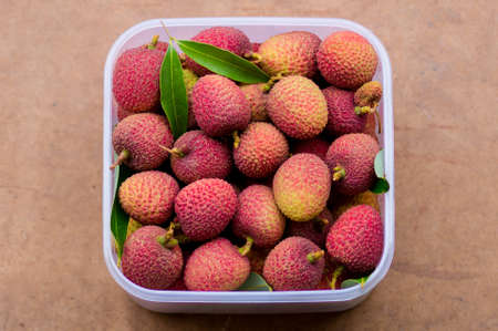 The fresh red lychees in the plastic box for eatingの写真素材