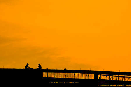 The workers are relax on the sunset background silhouetteの写真素材