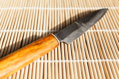 small knife on bamboo mat.