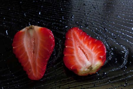 cutting strawberry on black tray.の写真素材