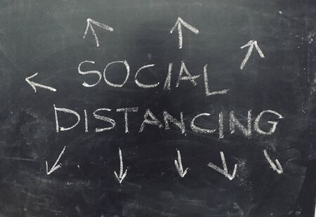 Social Distancing in the event of coronavirus pandemic handwritten on Blackboard as JPG File