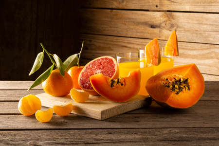 Oranges, papaya and grapefruit on wooden backgroundの写真素材