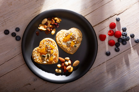 Heart shaped pancakes with oat, blueberries, raspberries, nuts and honey.の写真素材