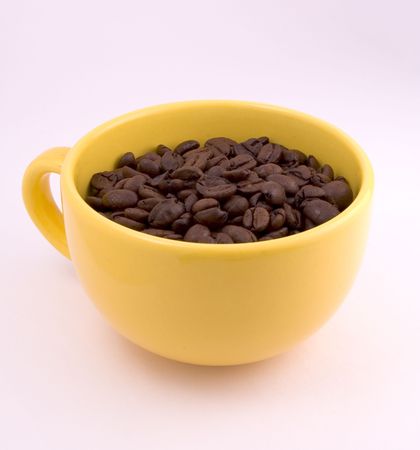 close-up of yellow cup full of coffee beansの写真素材