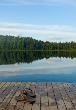 pair of slippers on a pier of the lake