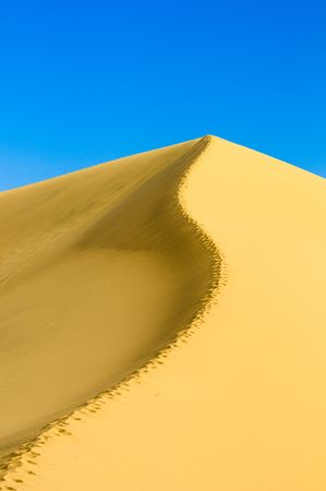 sand dunes over blue sky